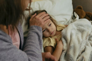 Mother comforting sick child at night in Torrance home